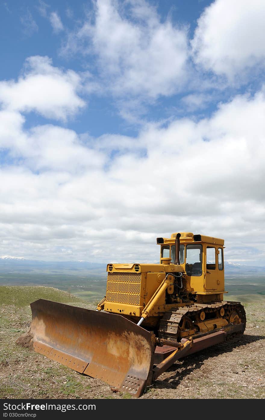 Excavator against cloudy blue sky background for your design. Excavator against cloudy blue sky background for your design