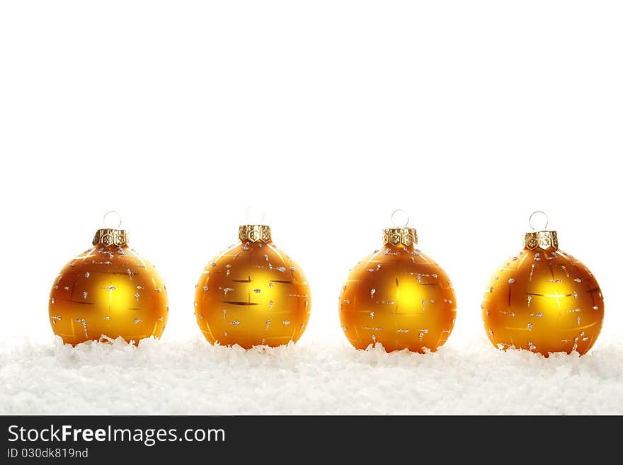 Four yellow (gold) Christmas ball in the series lie in the snow. Isolated on white background. Four yellow (gold) Christmas ball in the series lie in the snow. Isolated on white background