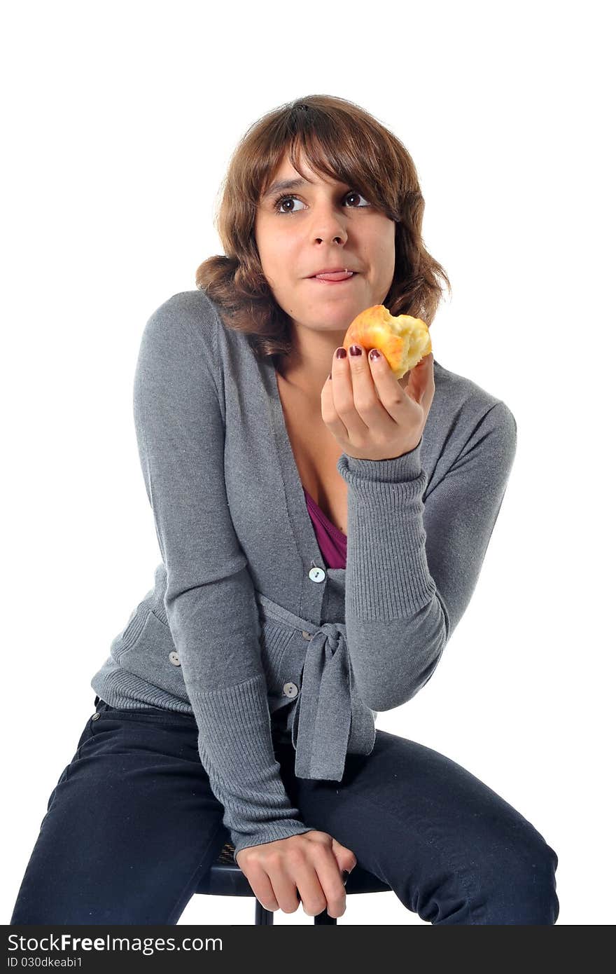 Beautiful teenager eating an apple in front of a white background. Beautiful teenager eating an apple in front of a white background