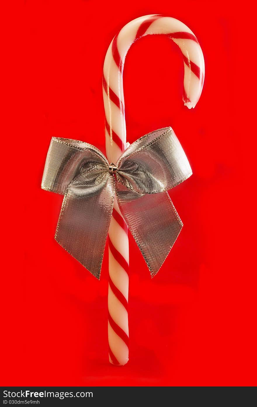 Candy cane with silver bow over red