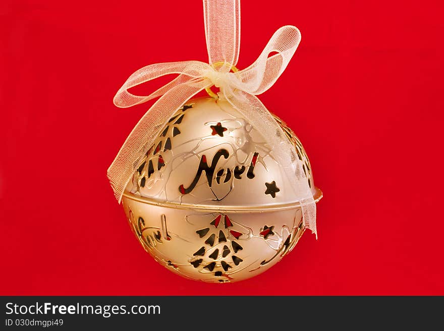 Gold bauble isolated on a red background. Gold bauble isolated on a red background