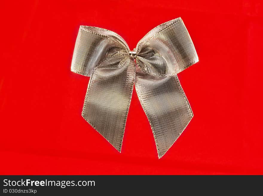 Single silver bow isolated on red