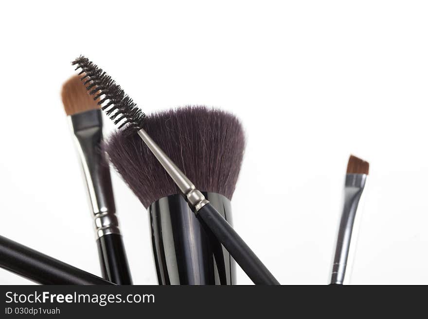 A detail of a make-up brushes composition, in a random position, shot on white background. A detail of a make-up brushes composition, in a random position, shot on white background.