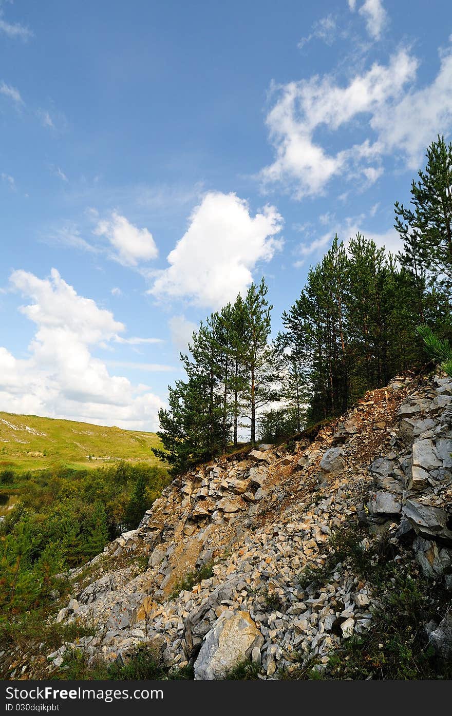 Summer rock with white clouds and slope