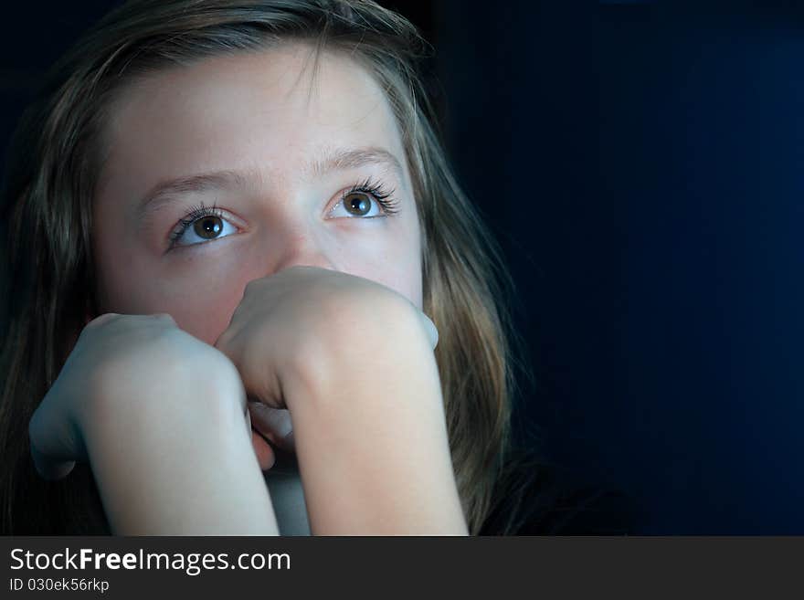 Nice young girl looking up portrait on dark background with copy space. Nice young girl looking up portrait on dark background with copy space