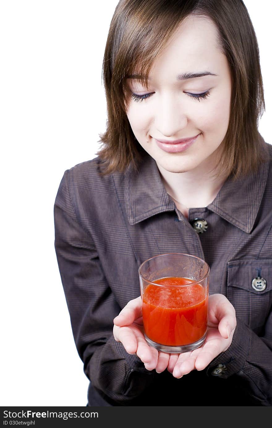 Smiling girl holding the glass of tomato juice isolated