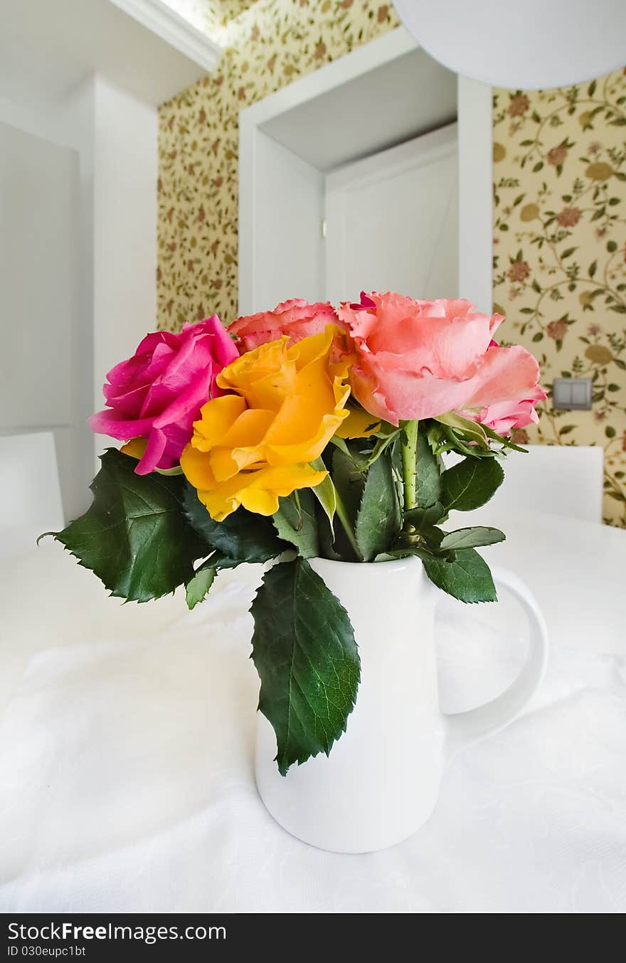 Colored roses in white vase, close-up photo