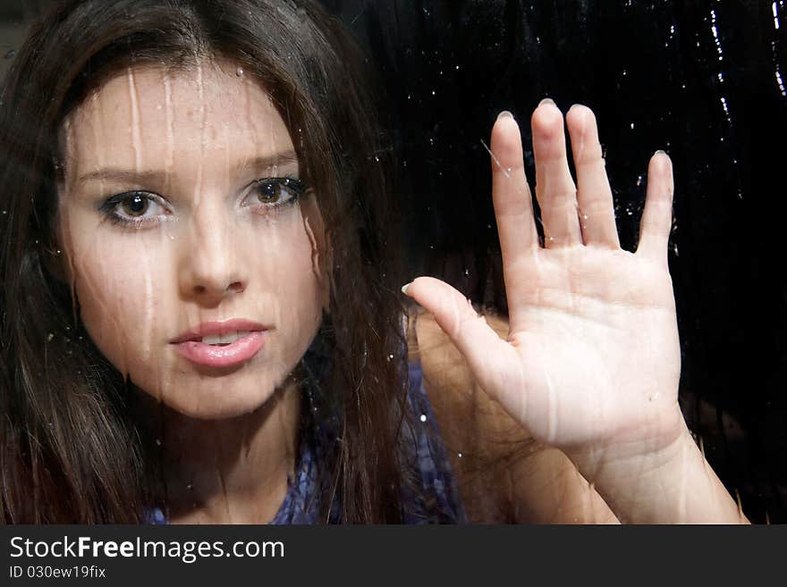 Girl behind wet window