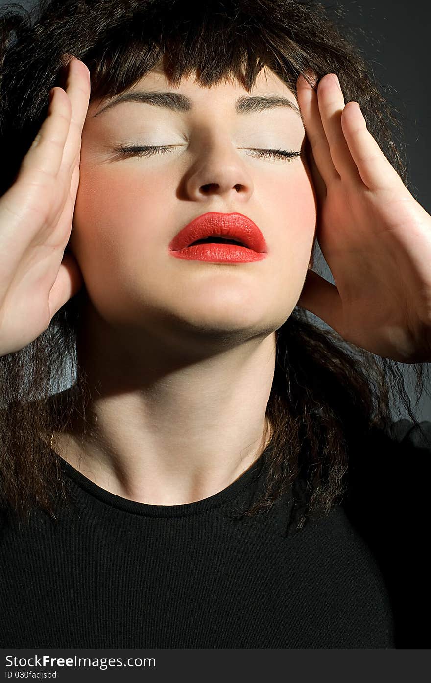 Woman with headache holding hands to head