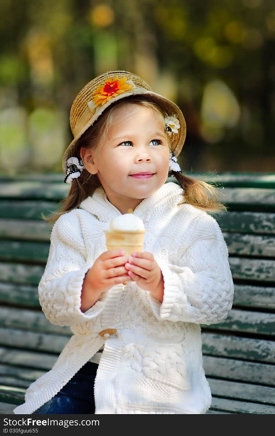 Portrait of small thinking girl with ice cream in autumn park. Portrait of small thinking girl with ice cream in autumn park