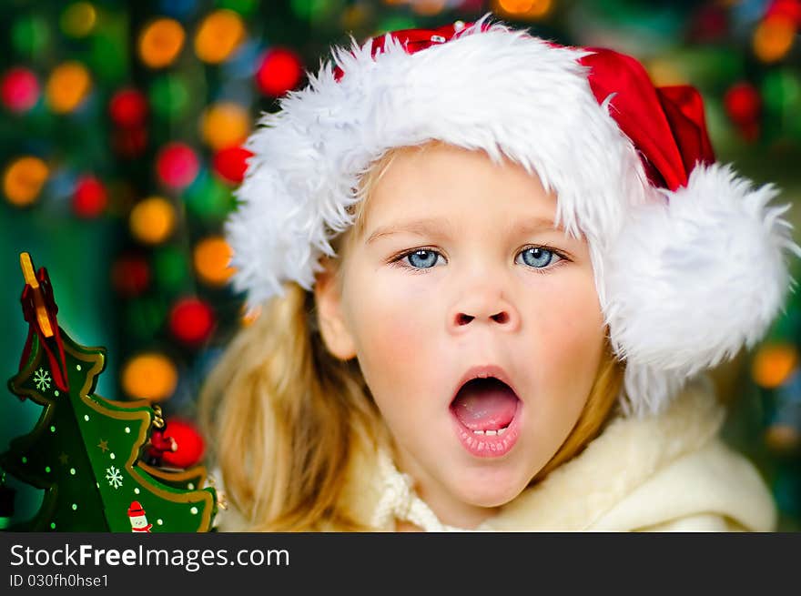 Surprised small girl in Santa's hat looking for a Christmas gifts. Surprised small girl in Santa's hat looking for a Christmas gifts