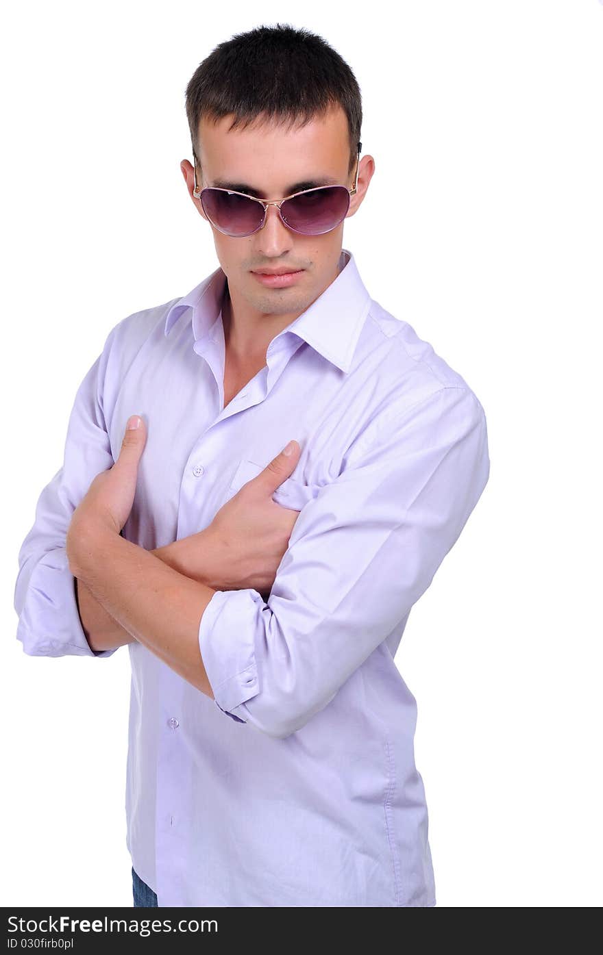 A young man in jeans and a light shirt and dark glasses