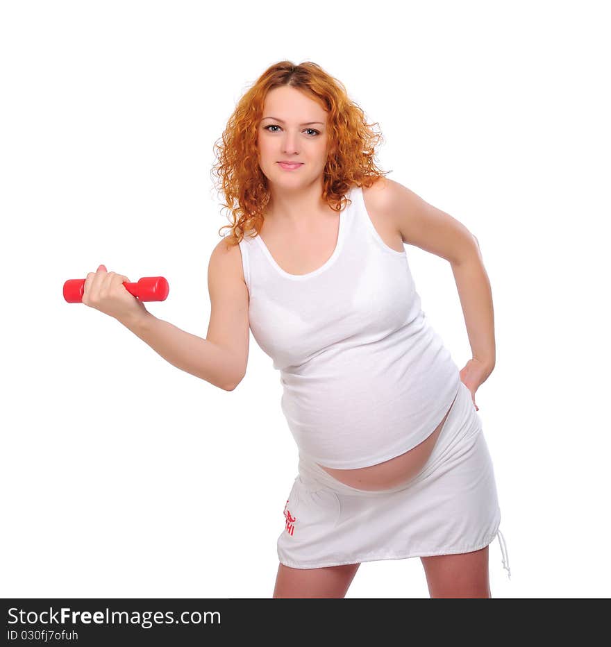 Young red-haired pregnant girl is engaged in sports.