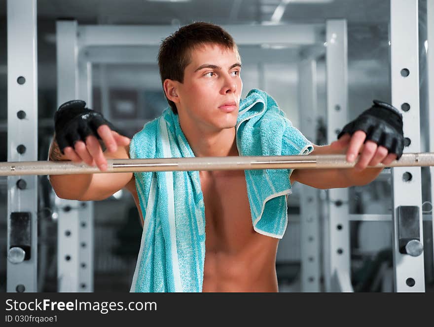 Muscular man working with heavy rod