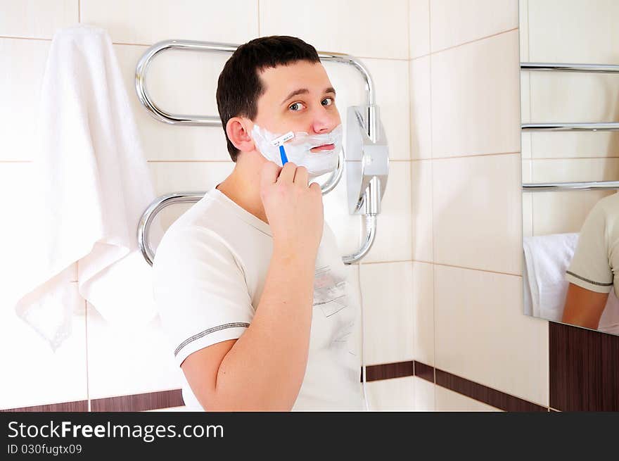 Young man shaving in his bathroom