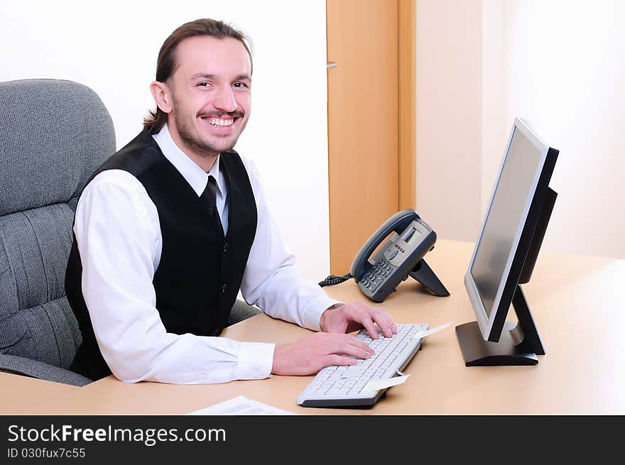 A young business man working on the computer in the office.