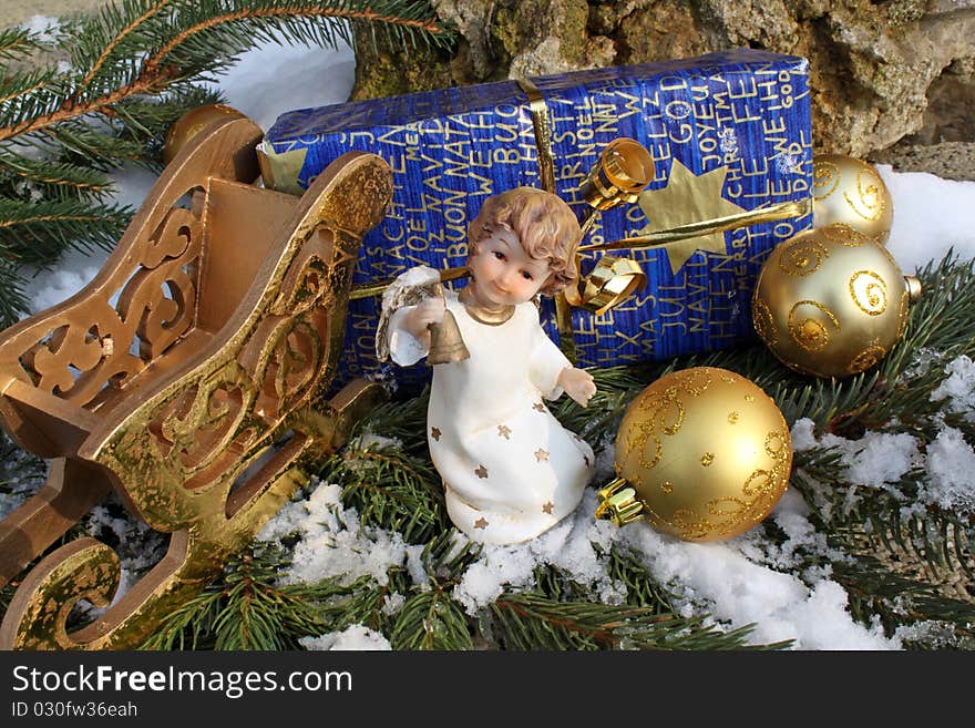 Angel with a Christmas gift in snow