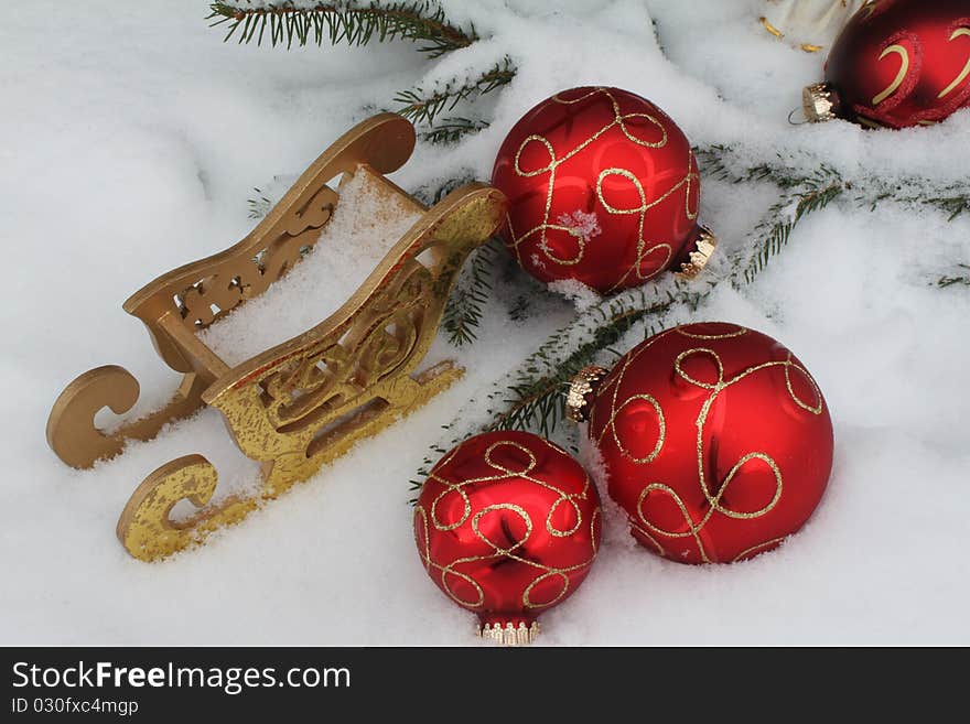 Red Christmas balls with sledge in snow