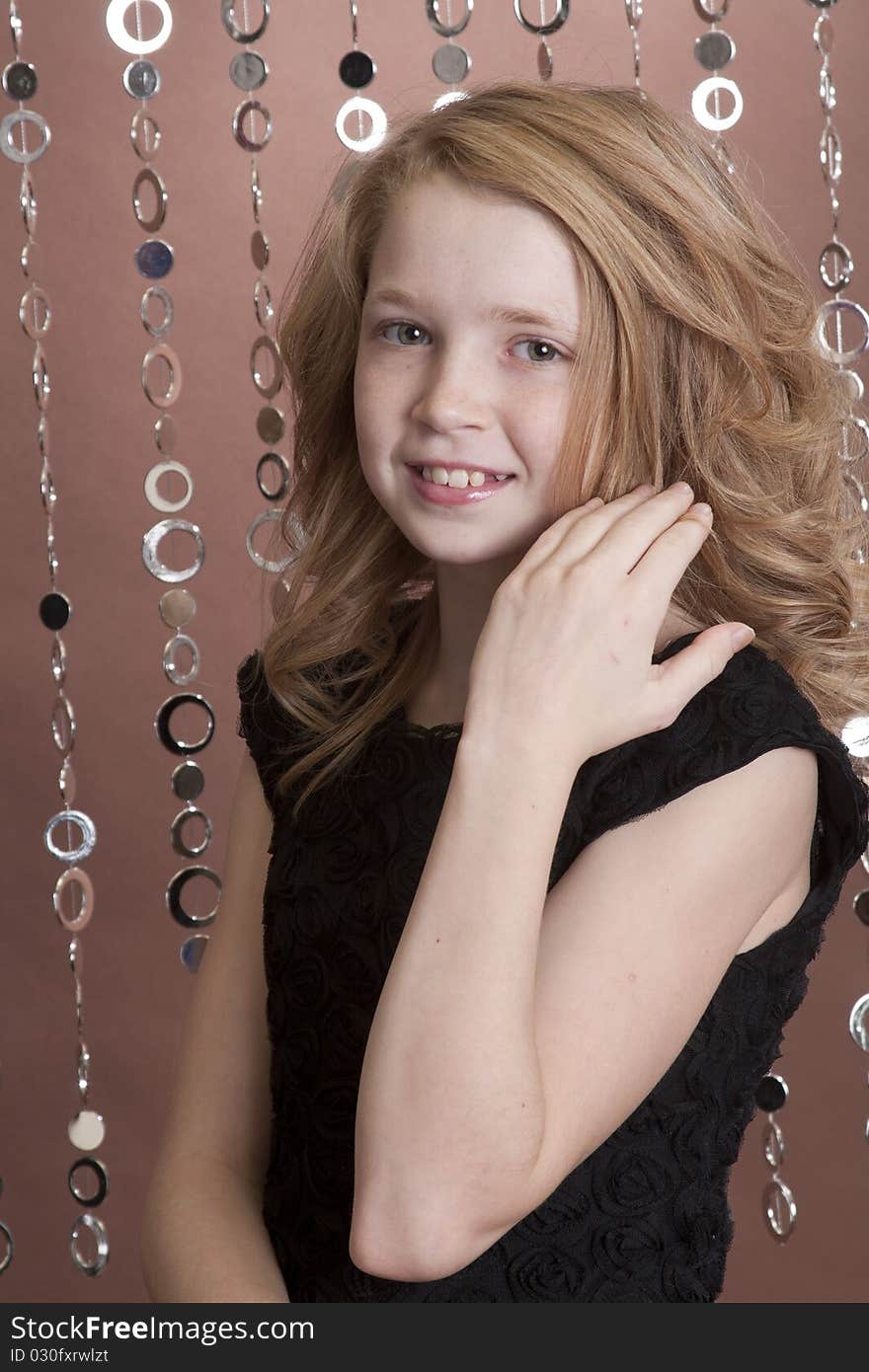 Beautiful young girl moving her hair away from her face as she poses for the camera. Beautiful young girl moving her hair away from her face as she poses for the camera