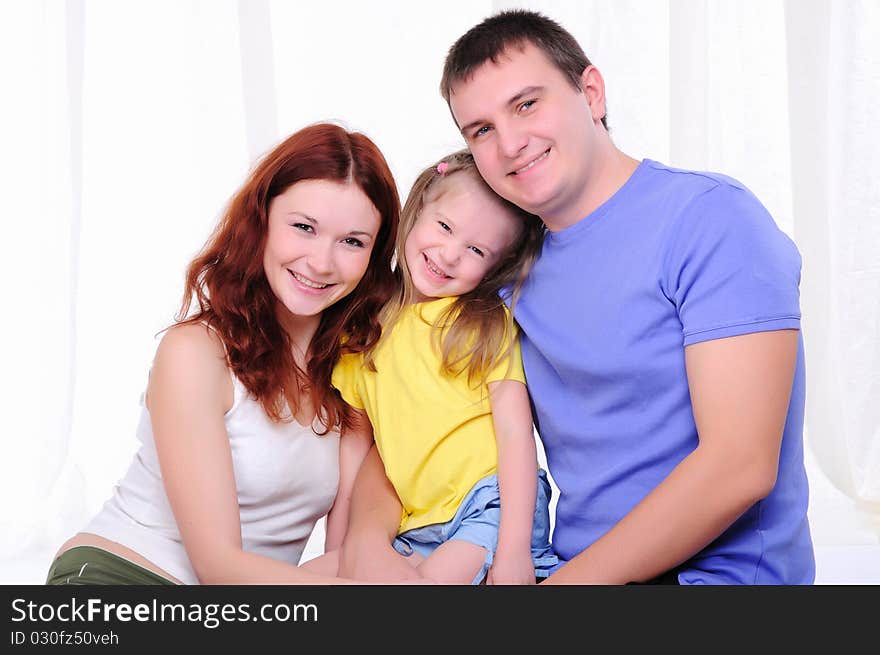 Young mother, a young father and young daughter have fun together