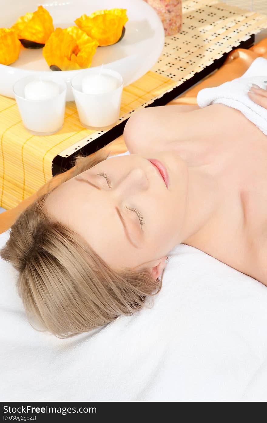 Woman in spa on white towel with blond hair