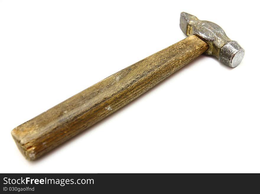 The old metal hammer with the wooden handle lies on a white background. The old metal hammer with the wooden handle lies on a white background