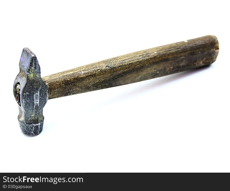 The old metal hammer with the wooden handle lies on a white background. The old metal hammer with the wooden handle lies on a white background