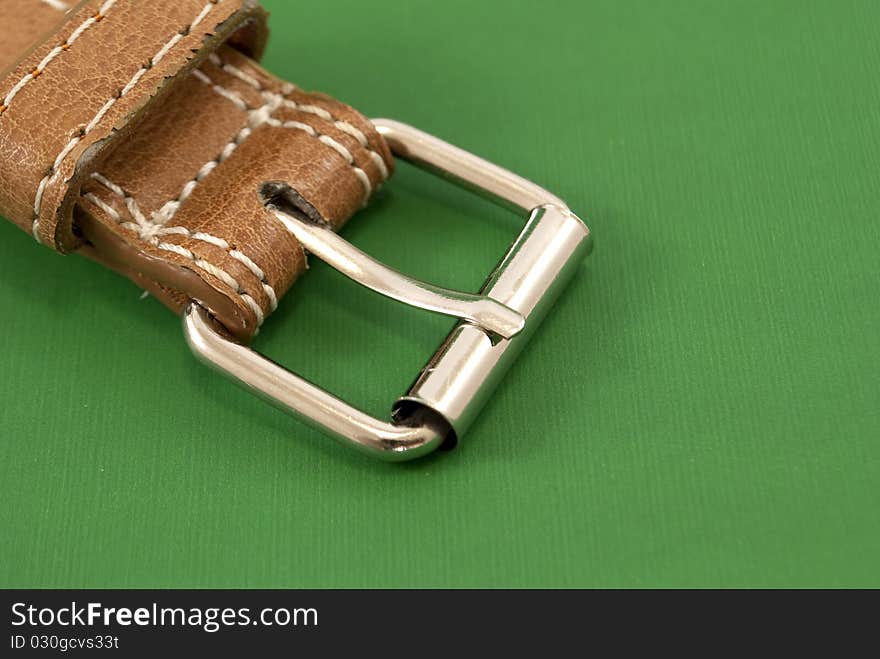 Leather belt buckle macro closeup green background