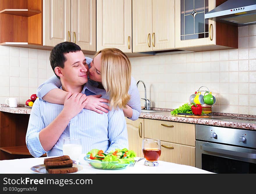 The wife and husband have breakfast together in his kitchen.