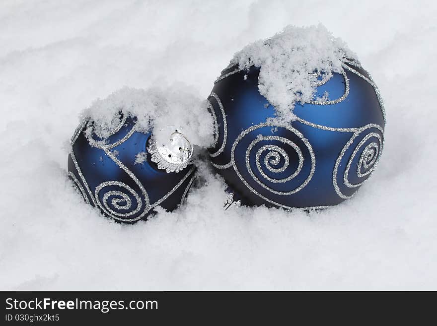 Two blue Christmas balls in snow