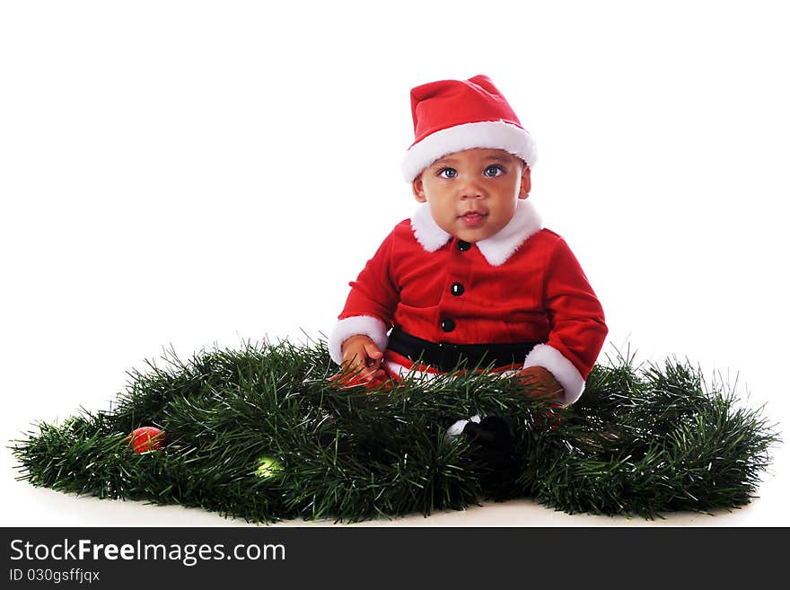 An adorable biracial baby dressed as Santa, sitting in the midst of Christmas garland. Isolated on white. An adorable biracial baby dressed as Santa, sitting in the midst of Christmas garland. Isolated on white.