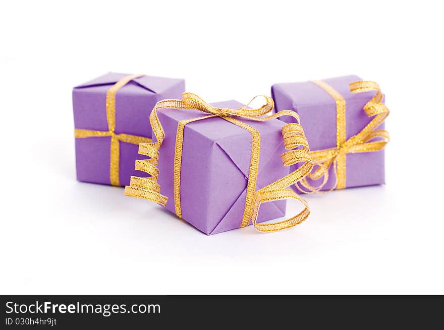 Lilac boxes with golden ribbon isolated on white background. Lilac boxes with golden ribbon isolated on white background