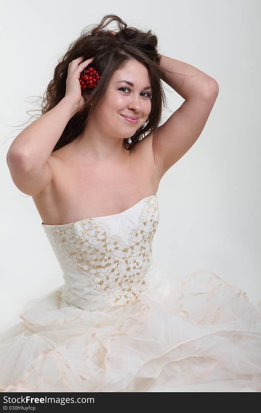 Smiling bride in wedding dress and berries in her hair