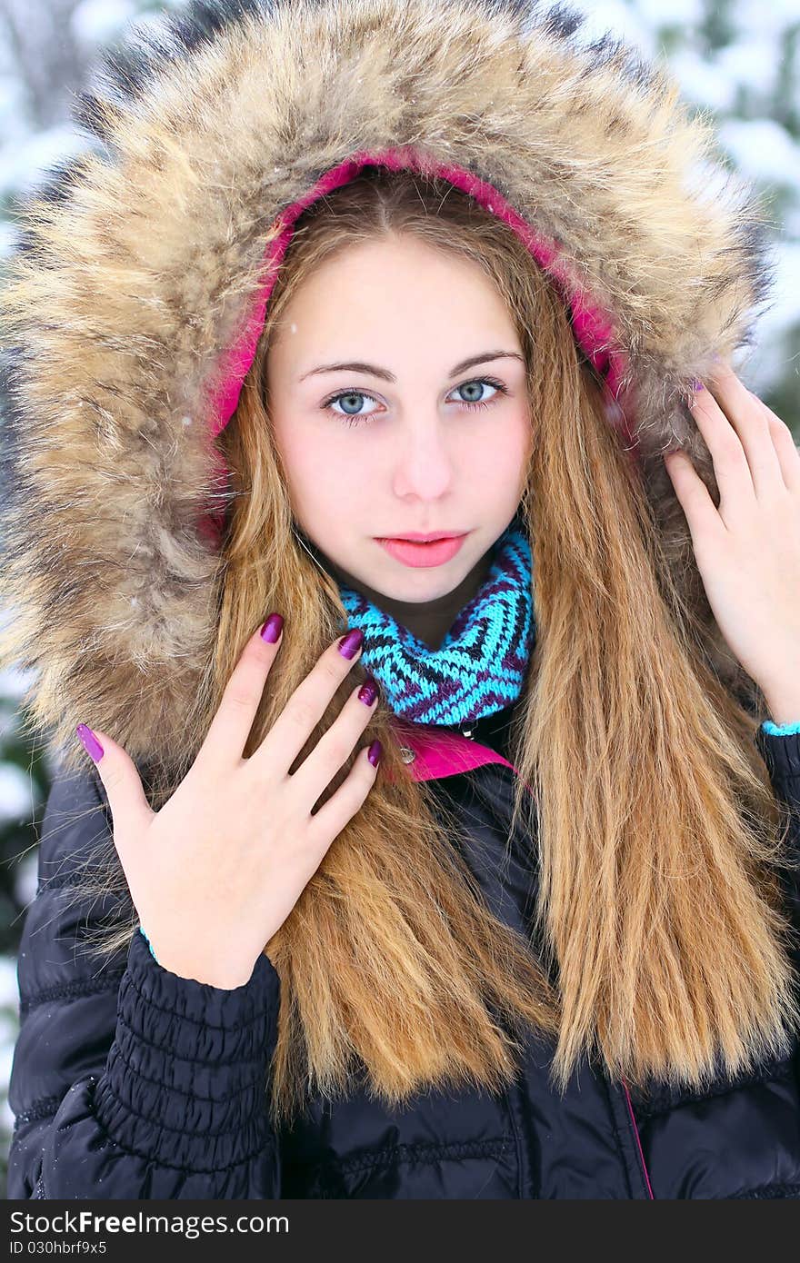 A teenage girl wearing a wintercoat with a furry hood. A teenage girl wearing a wintercoat with a furry hood