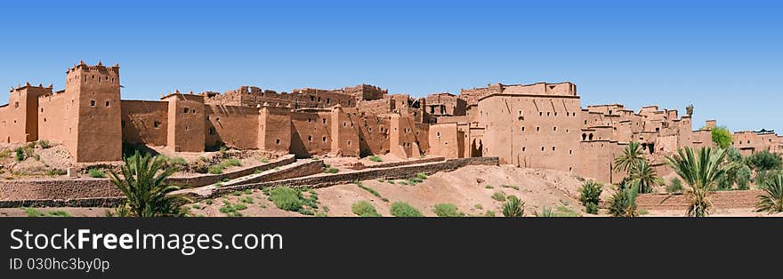 A panorama of a Moroccan kasbah with some trees on a summers day. A panorama of a Moroccan kasbah with some trees on a summers day.