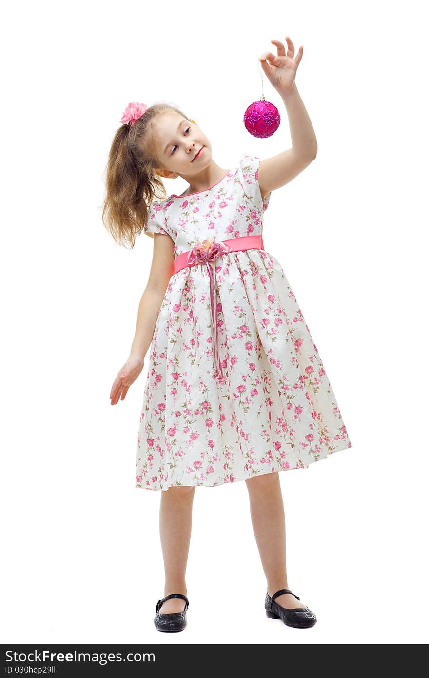 Cute little girl in dress playing with a christmas-tree decoration on white background isolated