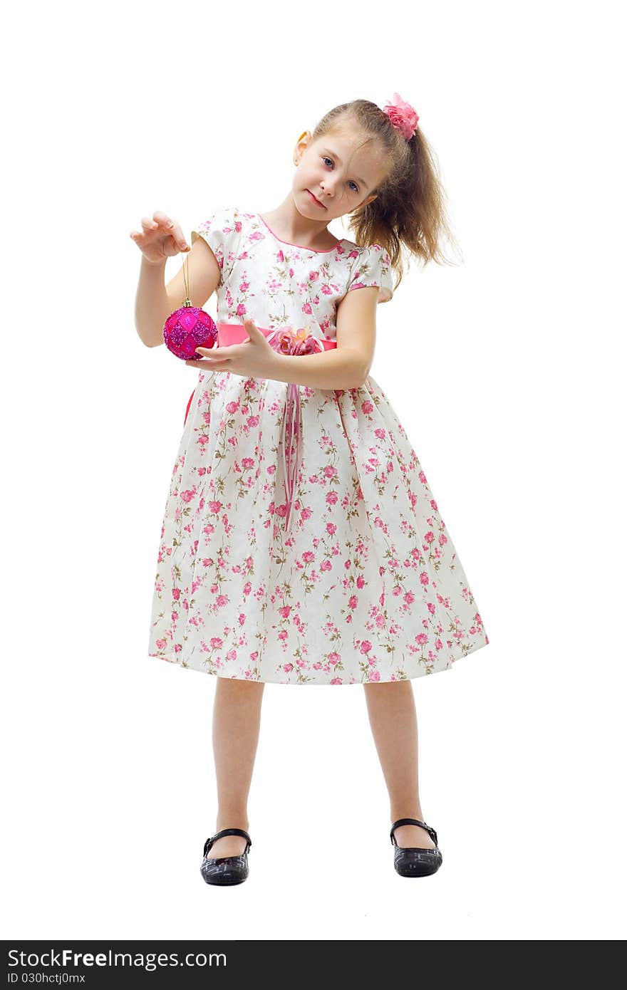 Cute little girl in dress playing with a christmas-tree decoration on white background isolated