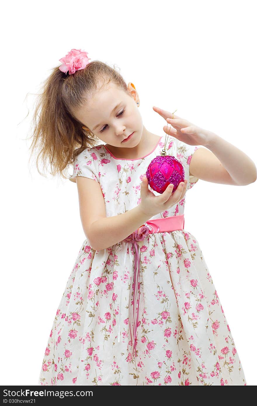 Cute little girl in dress playing with a christmas-tree decoration on white background isolated