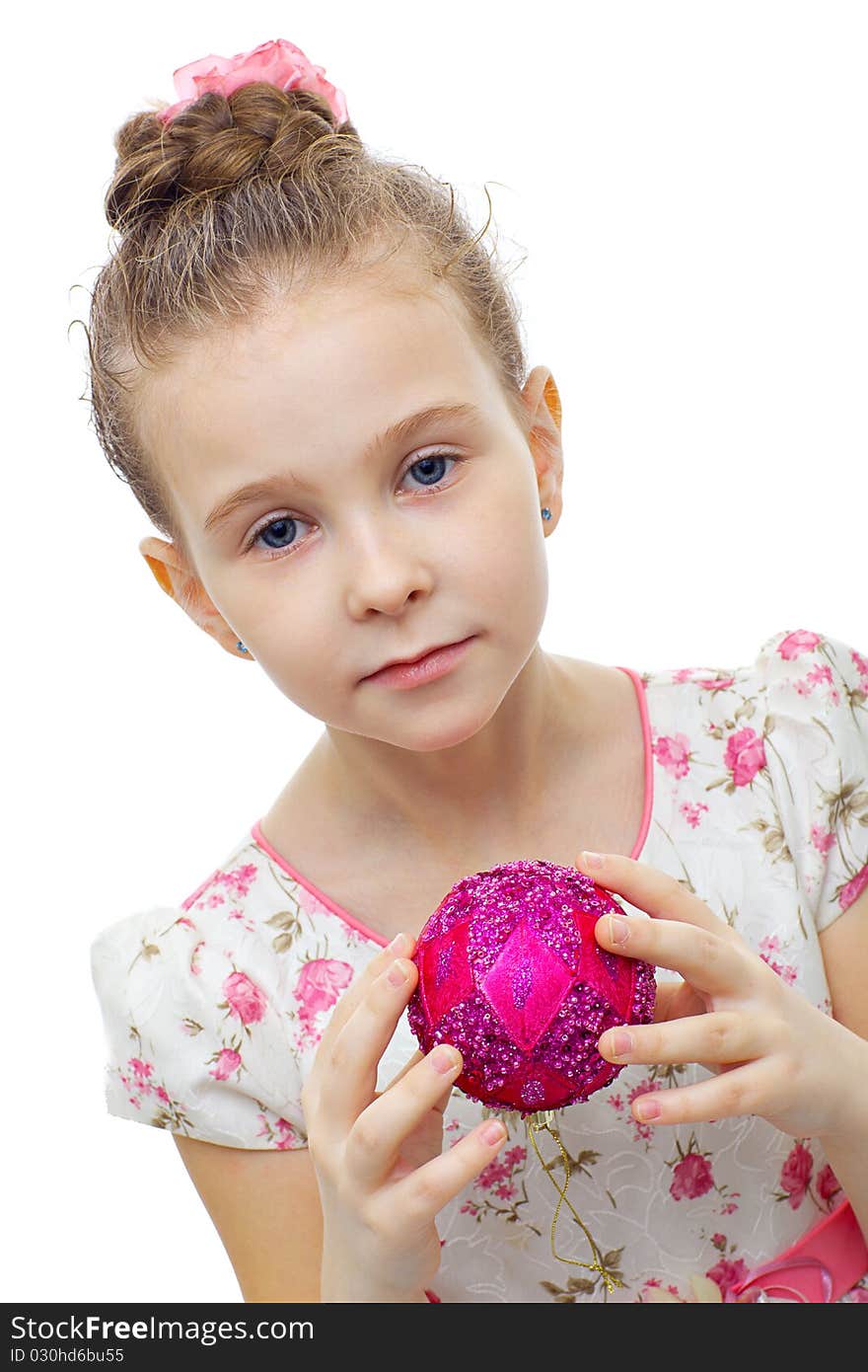 Cute little girl in dress playing with a christmas-tree decoration on white background isolated