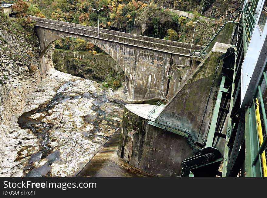 A dam with hydroelectric plant in a mountain river. A dam with hydroelectric plant in a mountain river