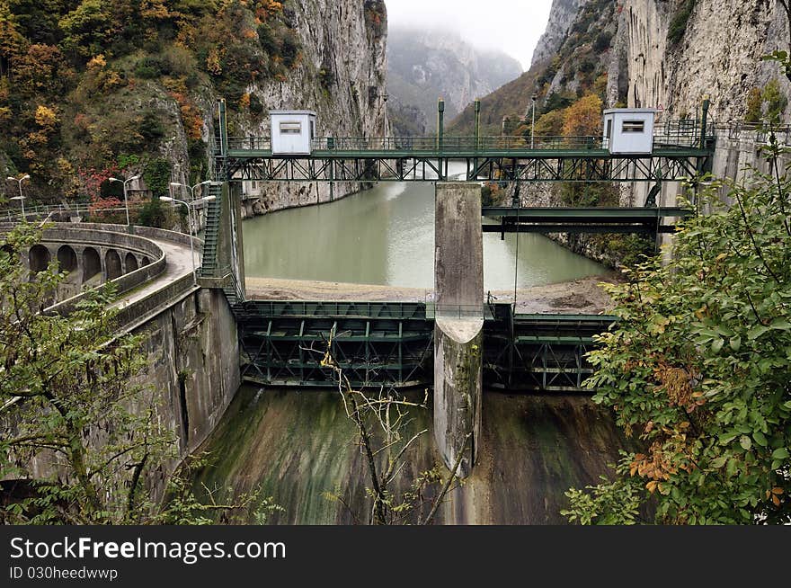 A dam with hydroelectric plant in a mountain river. A dam with hydroelectric plant in a mountain river