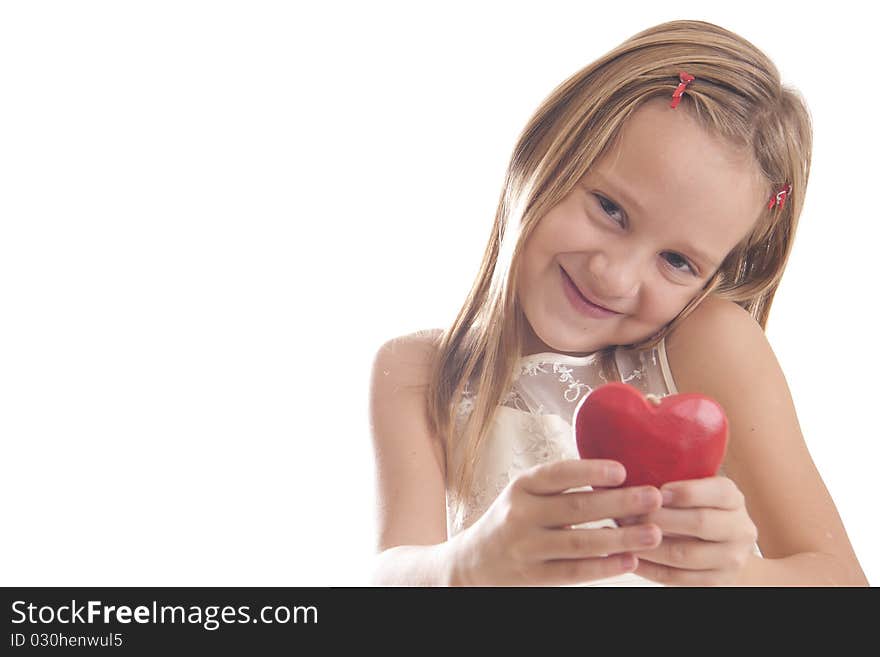 The girl holds red small red heart and smiling. The girl holds red small red heart and smiling