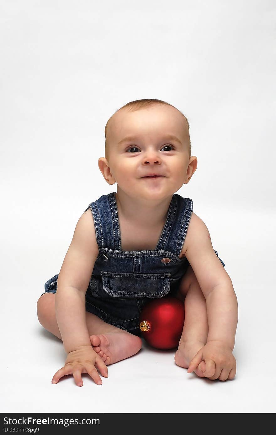 Baby playing with the Christmas glass ball on the white background. Baby playing with the Christmas glass ball on the white background