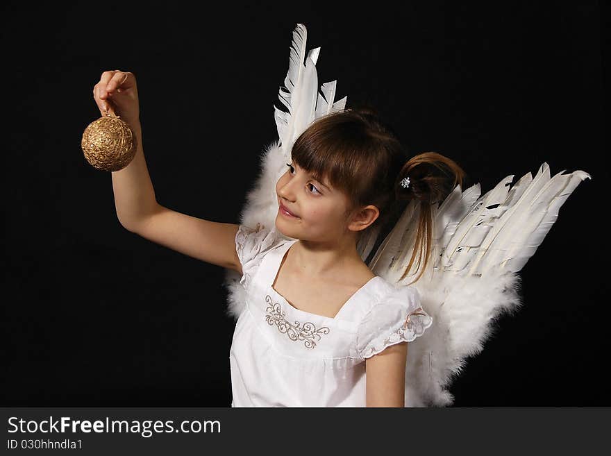 Girl playing with the Christmas glass ball on the black background. Girl playing with the Christmas glass ball on the black background