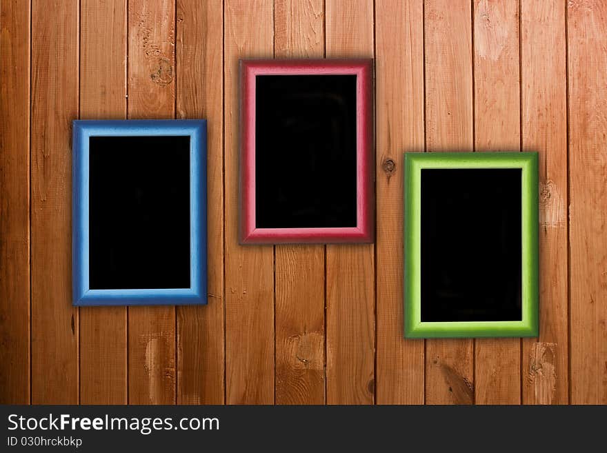 Three colorful frames hanging on wooden wall. Three colorful frames hanging on wooden wall