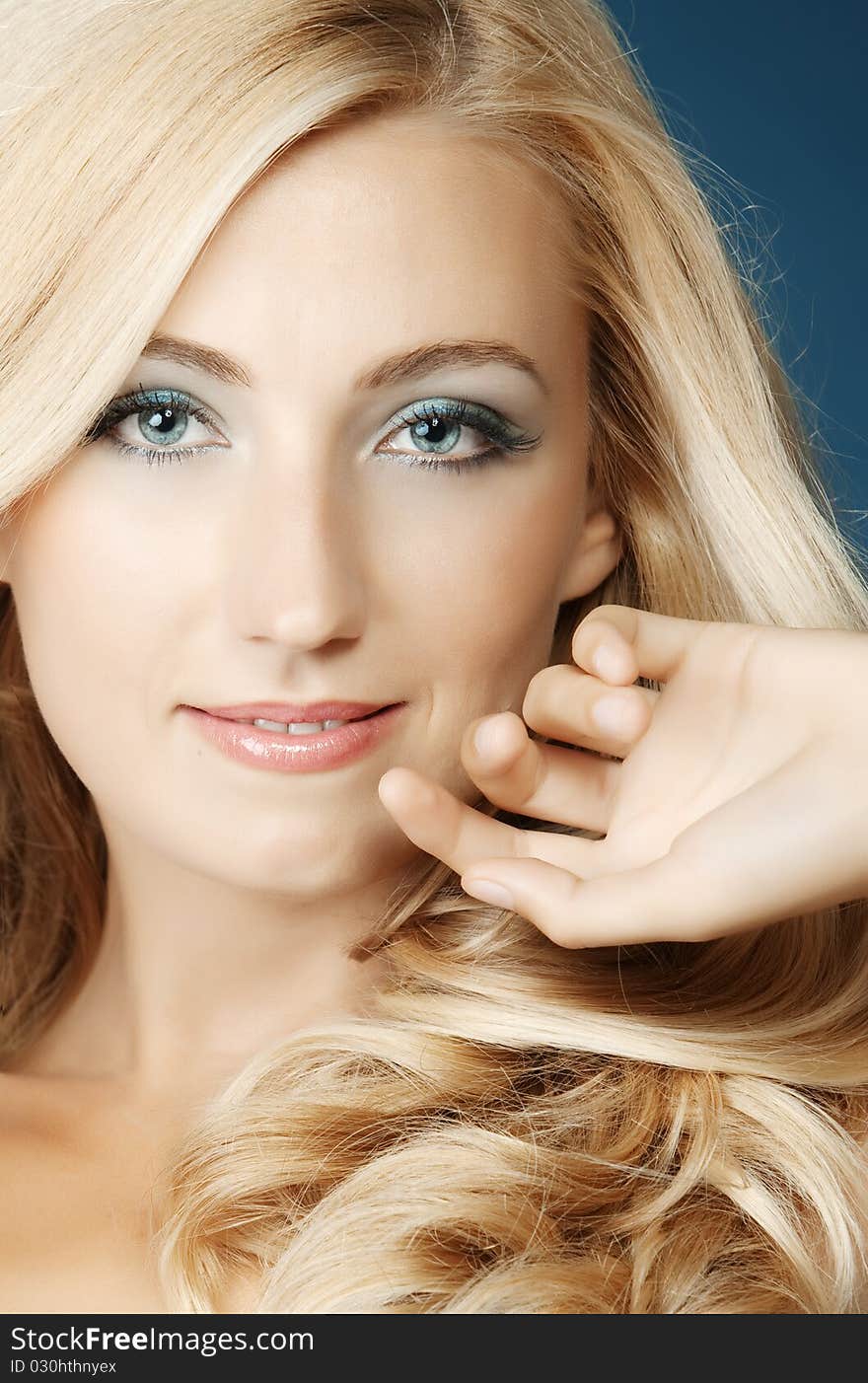 The beautiful girl in a blue dress on a dark blue background