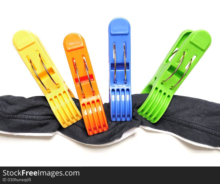 Four colorful clothes pegs and black t-shirt over white background. Four colorful clothes pegs and black t-shirt over white background