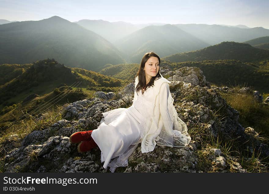 Beautiful bride posing on rocks in high mountain scenery. Beautiful bride posing on rocks in high mountain scenery