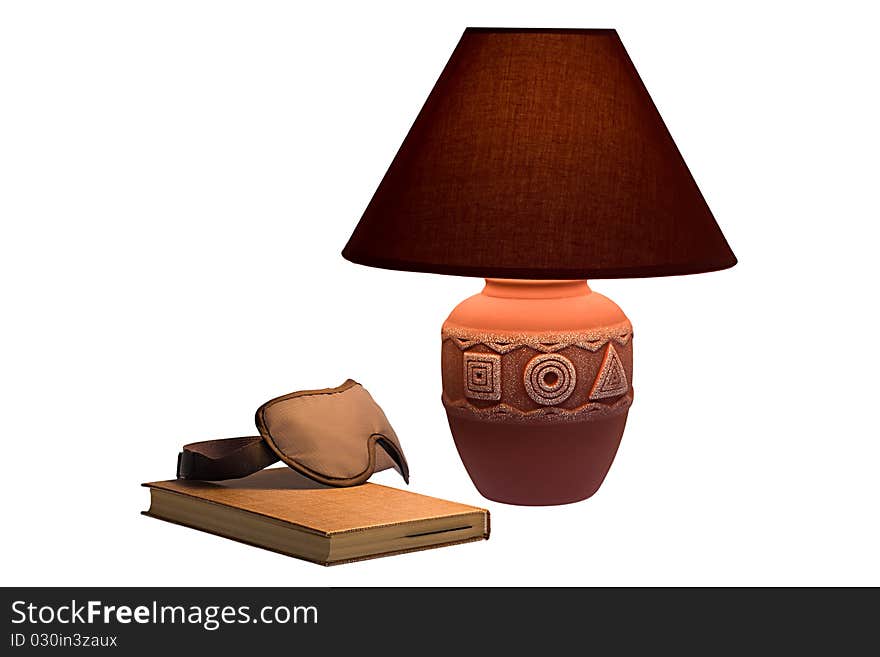 Cloth glasses for sleep lie on the book under the lamp. Cloth glasses for sleep lie on the book under the lamp