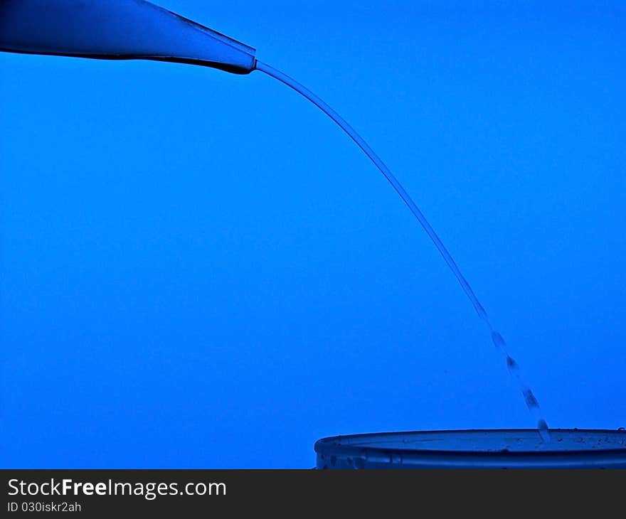 Pure water coming from a laboratory bottle and falling into another glass. Pure water coming from a laboratory bottle and falling into another glass